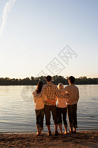 四个朋友站在湖边图片