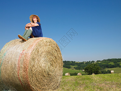车展上美胸坐在一捆干草上的女孩背景
