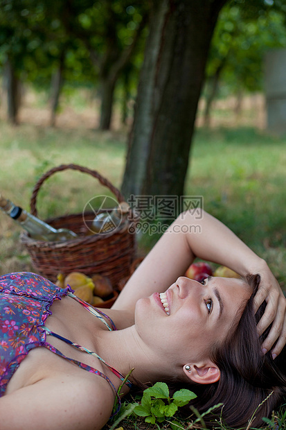 抱着一篮子水果躺在地上的女人图片