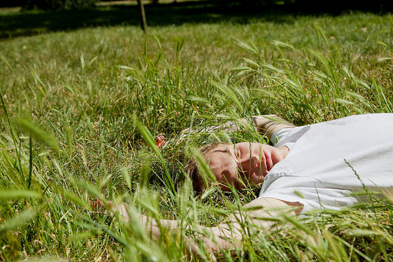 躺草地上的男孩图片