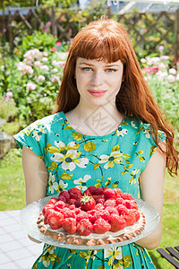 拿着草莓馅饼的年轻女人图片