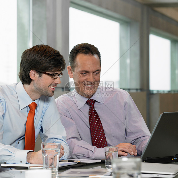 两个商人在看笔记本电脑图片
