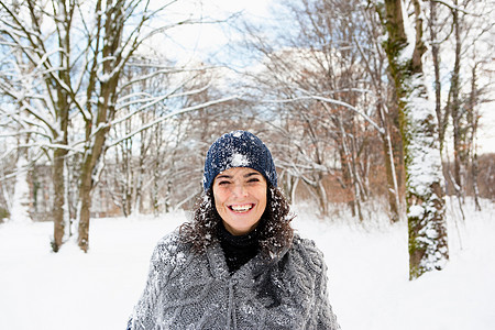 在白雪皑皑的树林里散步的女人图片