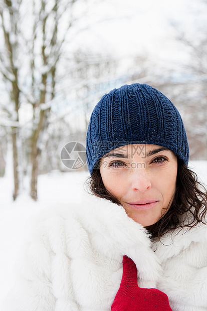 白雪皑皑的树林里的女人看着摄像机图片