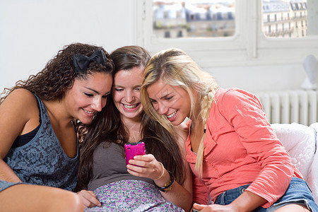 年轻女性在沙发上分享手机短信图片