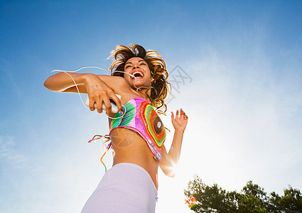 精力充沛的女人对着音乐播放器跳舞背景图片