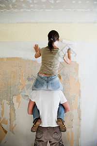 年轻夫妇粉刷墙壁图片