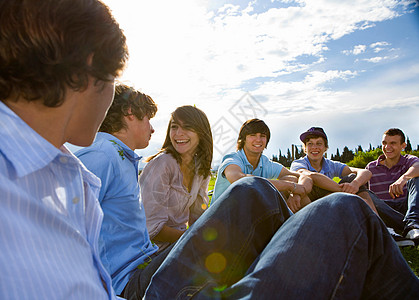 青少年坐在草地上聊天图片