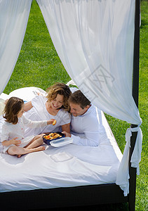 一家人在花园里的床上吃早餐图片