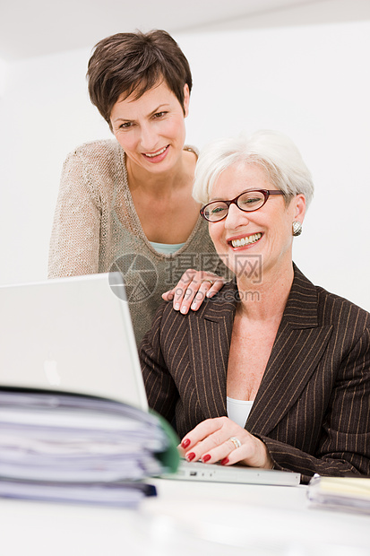 两个女人在电脑前一起工作图片