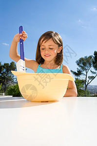 小女孩在碗里搅拌奶油图片
