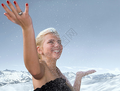 年轻女子在下雪中举起手来图片