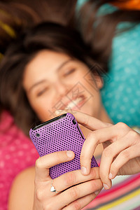 年轻女子在微笑着看电话图片