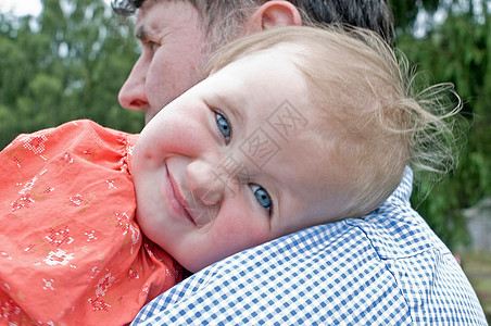 婴儿在爸爸的肩上微笑图片