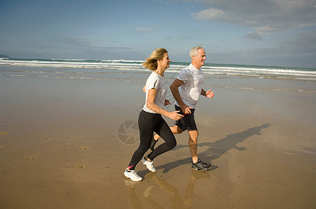 一对夫妇在海滩上奔跑图片