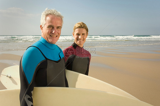 海滩上带冲浪板的情侣图片