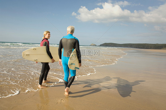 海滩上带冲浪板的情侣图片