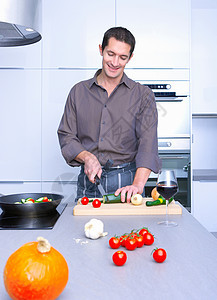 男人在厨房做饭，微笑着图片