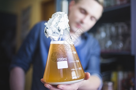 中年男子在家用酵母瓶酿啤酒背景图片