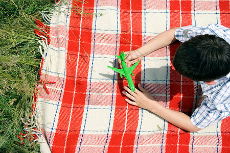 玩绿色玩具飞机的男孩图片