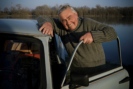 河边站在车旁的老人图片