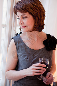 穿灰色衣服，喝着一杯酒的女人图片
