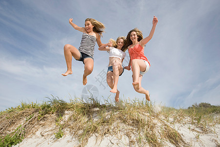 十几岁的女孩在海滩上跳跃图片