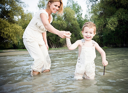 母亲抓着孩子的手走在水里图片
