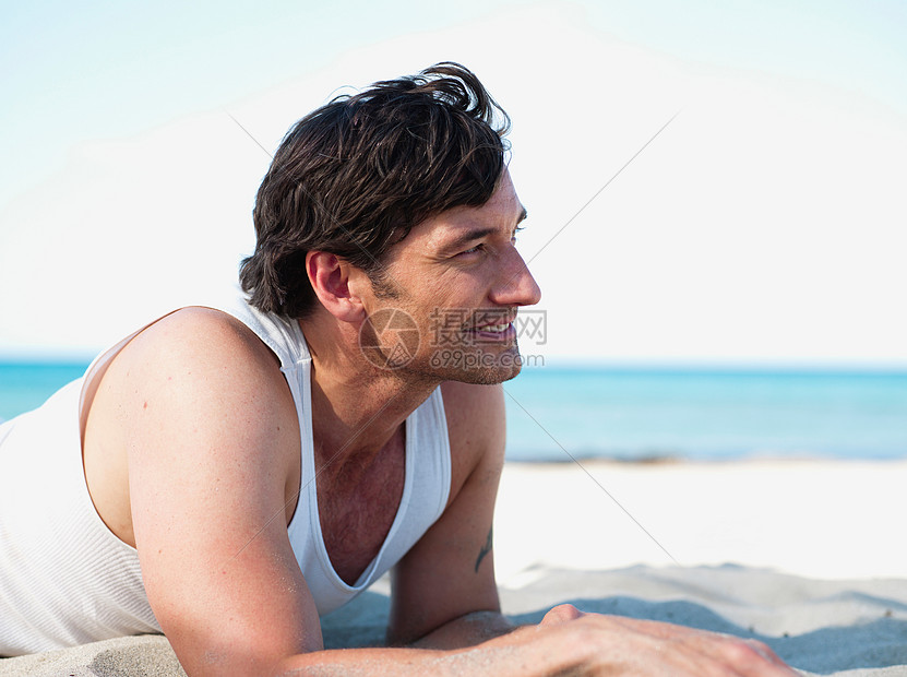 趴在沙滩上的男人图片