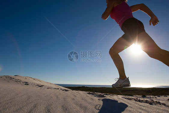 年轻女子在沙丘上奔跑图片