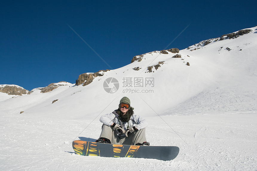 坐在雪地上的滑雪板图片