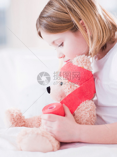 抱着泰迪熊在床上的女孩图片