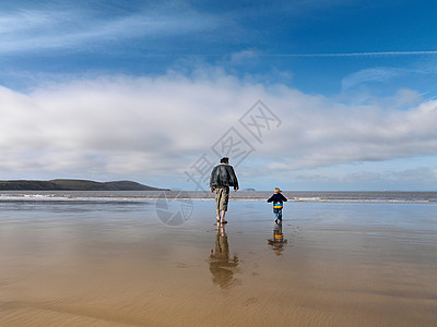 男人和孩子走向大海图片