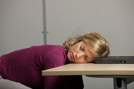 在办公桌上睡觉的女工人图片