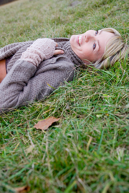躺在草地上微笑的女人图片