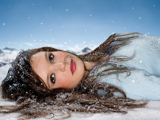 年轻女子躺在雪地里图片