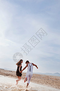 沿着海滩奔跑的夫妇图片