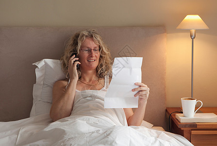 成熟的女人在床上打电话图片