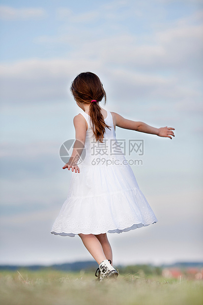 在草地上跳舞的年轻女孩图片