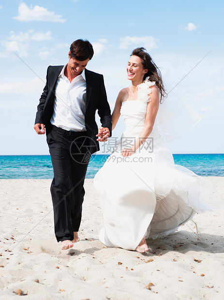 新郎新娘沿着海滩奔跑图片