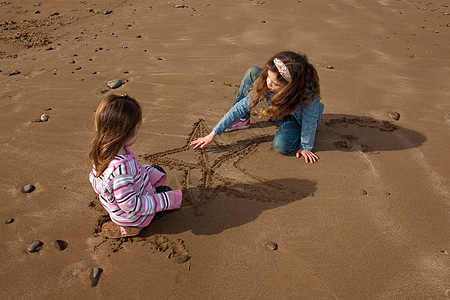 2个孩子在海滩上画星星图片
