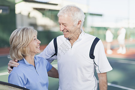 在网球场拥抱的老年夫妇图片