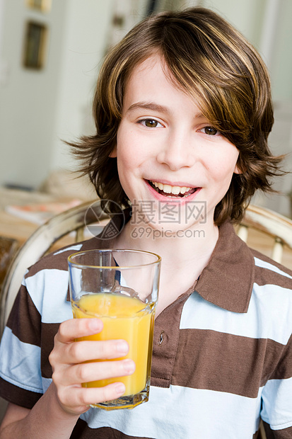 男孩微笑着喝橙汁图片