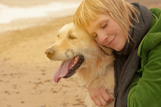 海滩上抱着狗的女人图片
