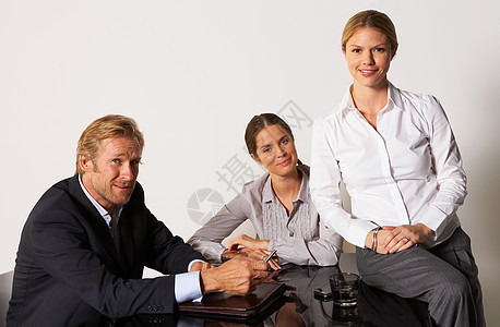 三个商人坐在桌子旁微笑图片