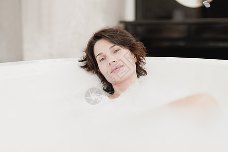 微笑的女人洗泡泡浴图片