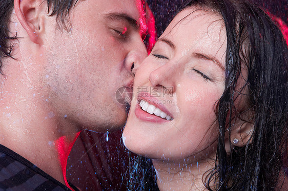 年轻夫妇在雨中接吻图片