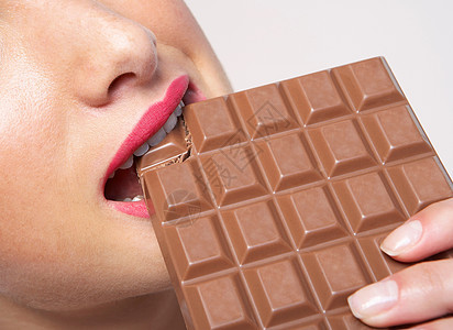 女人咬着一大块巧克力图片