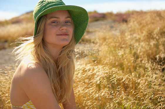 坐在草里的年轻女子图片