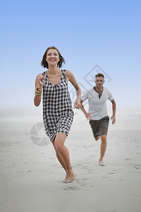 一对夫妇在海滩上互相追逐图片